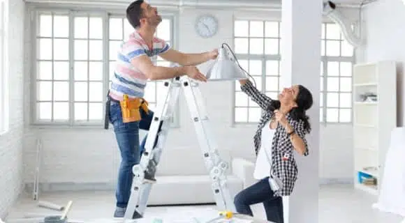 Couple Using Ladder To Install a Hanging Light — Engineering and Fabrication Products in Bungalow, QLD